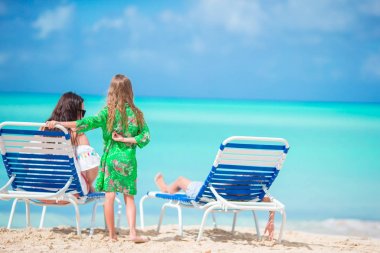 Güzel anne ve sevimli küçük kızları sahilde