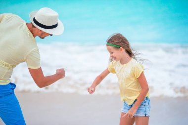Mutlu baba ve sevimli küçük çocuğunu tropik sahilde birlikte eğleniyor