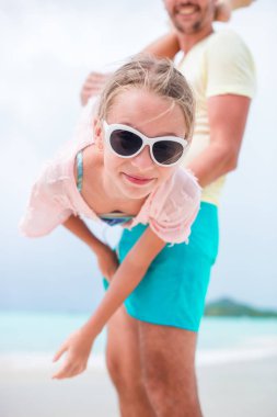 Küçük kız açık havada yaz tatili sırasında babası ile iyi eğlenceler. Gökyüzü arka plan üzerinde baş aşağı bir çocuk portresi