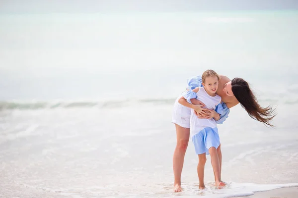 Beautiful mother and daughter on white beach — Stock Photo, Image