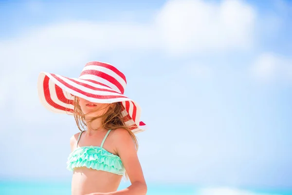 Entzückendes kleines Mädchen mit großem Hut am weißen Strand — Stockfoto