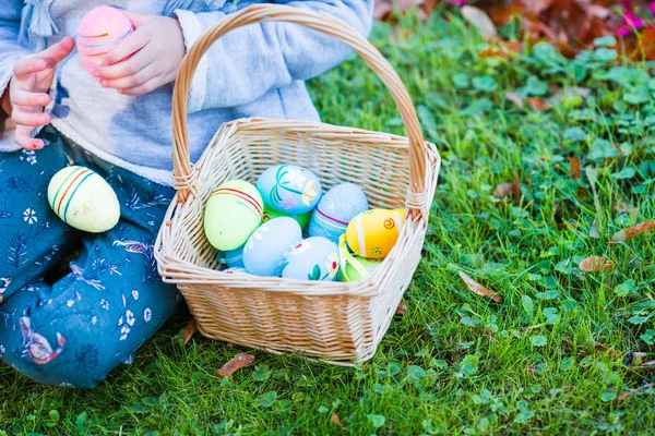 Closeup basket full of colorful Easter eggs in kids hands — Stock Photo, Image