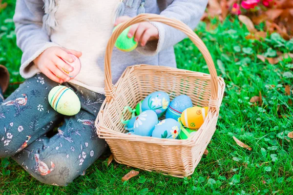 Closeup basket full of colorful Easter eggs in kids hands — Stock Photo, Image