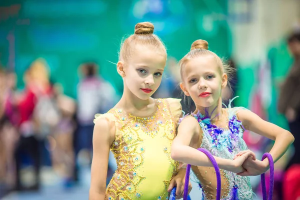 Little charming gymnasts with medals after the rhythmic gymnastics competition