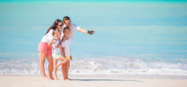 Мужчина фотографирует свою семью на пляже — стоковое фото