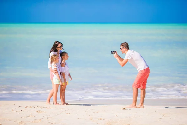माणूस समुद्रकिनारावर त्याच्या कुटुंबाचा फोटो घेऊन — स्टॉक फोटो, इमेज
