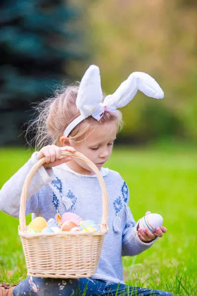 Portrait de petite fille avec un panier plein d'œufs de Pâques le jour du printemps en plein air — Photo