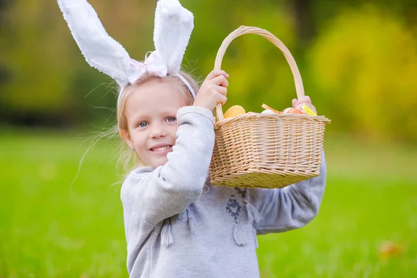 Ritratto di bambina con un cesto pieno di uova di Pasqua il giorno di primavera all'aperto — Foto Stock