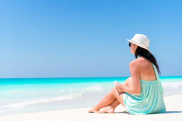 Mujer sentada en la playa disfrutando de vacaciones de verano —  Fotos de Stock