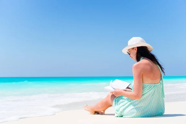 Νεαρή γυναίκα διαβάζει βιβλίο κατά τη διάρκεια τροπική λευκή παραλία — Φωτογραφία Αρχείου