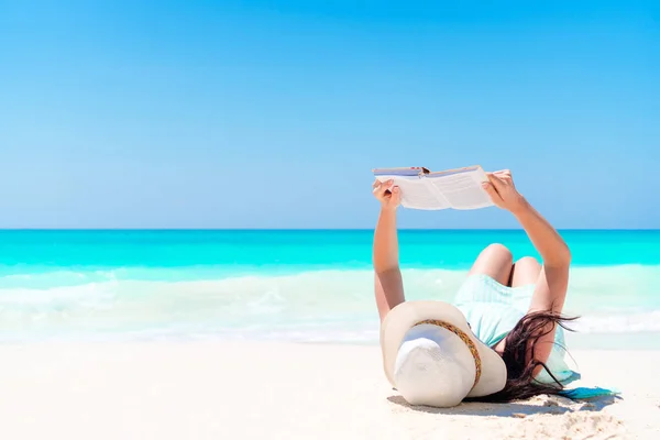 Молодая женщина читает книгу во время тропического белого пляжа — стоковое фото