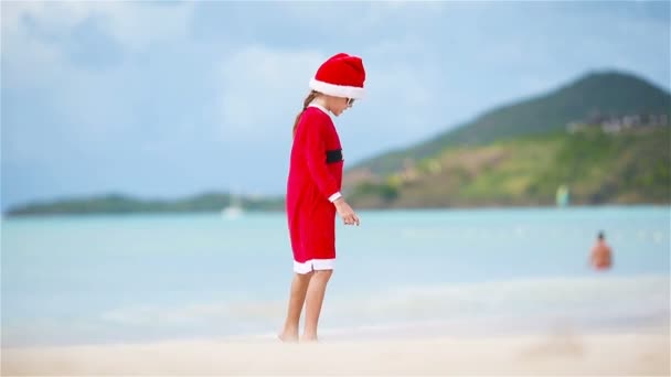 Entzückendes Mädchen mit Weihnachtsmütze am weißen Strand im Weihnachtsurlaub — Stockvideo