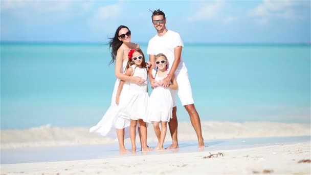 Молодая семья веселится на белом тропическом пляже Карибского моря — стоковое видео