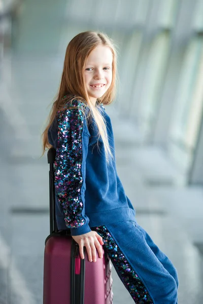 Adorable little girl in airport with her luggage waiting for boarding — Stock Photo, Image