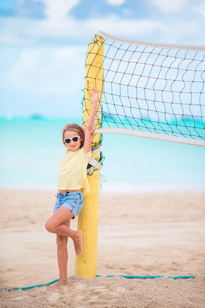 Schattig meisje spelen van beachvolleybal met bal. Sportieve kind genieten van beach potje buitenshuis — Stockfoto