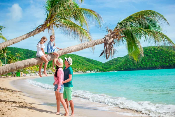 Bambine che si divertono sedute sulla palma. Felice famiglia rilassante sulla spiaggia tropicale con sabbia bianca e acqua turchese oceano — Foto Stock