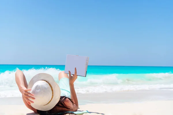 Vrouw met boek aan de kust — Stockfoto