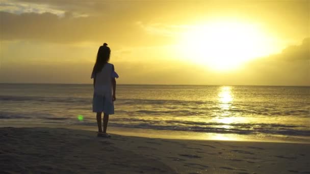 Imádnivaló boldog kis lány séta fehér tengerparton naplementekor. — Stock videók