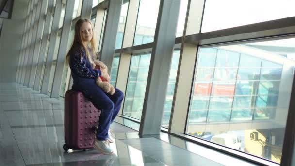 Rozkošná holčička na letišti se svými zavazadly čeká na nástup — Stock video