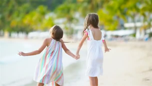 Aranyos kis lány séta a tengerparton, és a szórakozás együtt — Stock videók