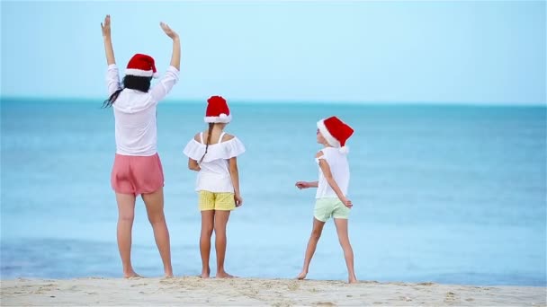 Вид сзади восхитительной девушки в рождественской шляпе на белом пляже во время рождественских каникул — стоковое видео