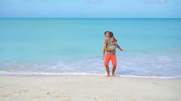 Маленькая девочка и счастливый папа веселятся во время отдыха на пляже — стоковое видео
