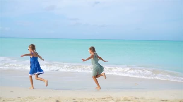 Weinig gelukkig grappige meisjes hebben een heleboel plezier op tropisch strand samenspelen. Slow Motion — Stockvideo