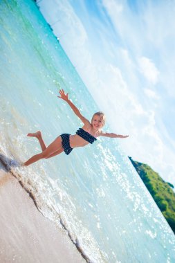 Küçük mutlu kız sıçramasına. Turkuaz su yüzmeyi hazır çalışan çocuk