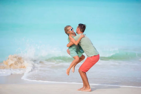 Pai feliz e sua adorável filhinha na praia tropical se divertindo — Fotografia de Stock