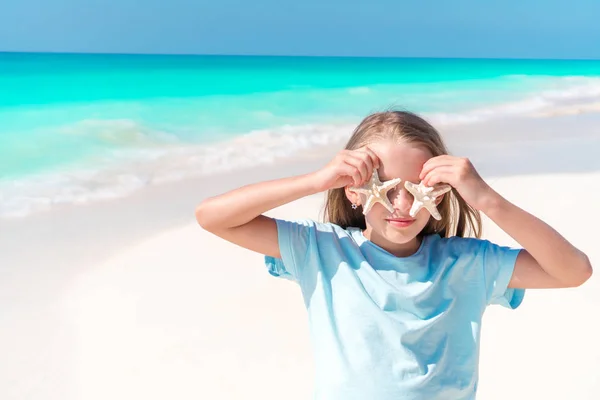 Malá holčička na bílé pláži s hvězdice — Stock fotografie
