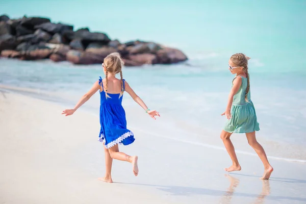 Lite glada roliga tjejer har mycket roligt på tropiska stranden leker tillsammans. — Stockfoto