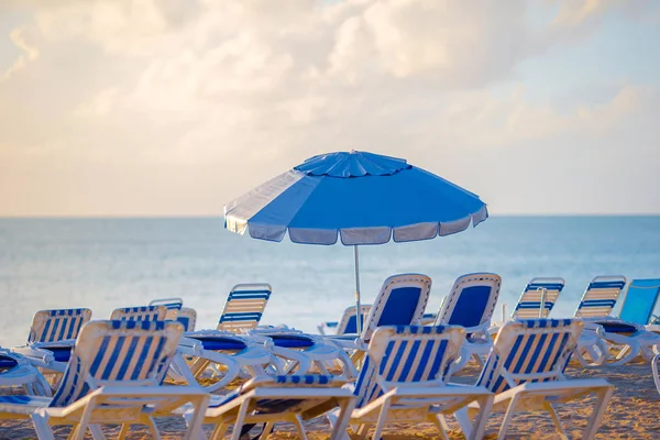 Playa pública en un popular resort en el Caribe con sombrillas y chaise-lounges — Foto de Stock