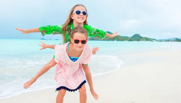 Duas meninas felizes se divertem muito na praia tropical jogando juntas — Fotografia de Stock