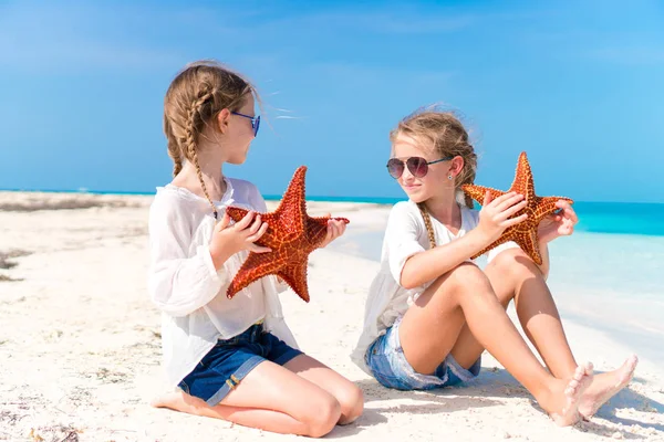 Rozkošné holčičky s hvězdice na bílé pláži — Stock fotografie
