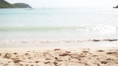 Antigua Adası'nda beyaz kum, turkuaz okyanus su ve mavi gökyüzü ile pastoral tropikal plaj