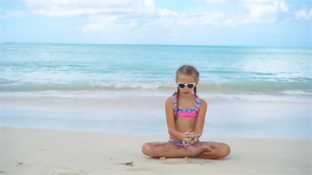 Αξιολάτρευτο κοριτσάκι στην παραλία κατά τη διάρκεια των καλοκαιρινών διακοπών — Αρχείο Βίντεο