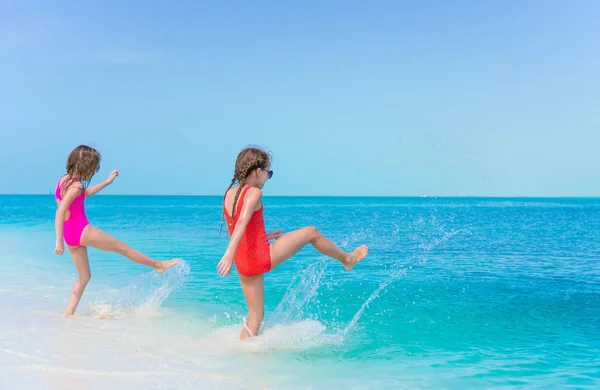 Kleine glückliche Mädchen planschen. Kinder rennen zum türkisfarbenen Wasser bereit zum Schwimmen — Stockfoto