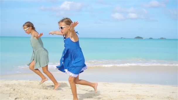 Kleine fröhliche lustige Mädchen haben viel Spaß am tropischen Strand beim gemeinsamen Spielen. — Stockvideo