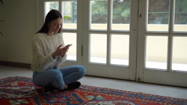 Νεαρή γυναίκα συνεδρίαση σε θέση lotus εσωτερική — Αρχείο Βίντεο