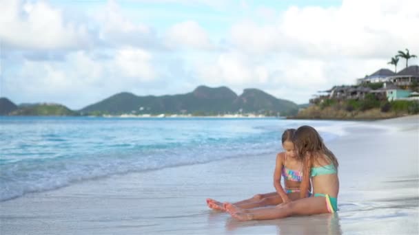 Bedårande små flickor avkopplande på stranden — Stockvideo