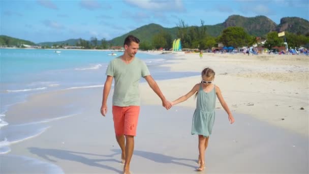 Pai feliz e sua adorável filhinha na praia tropical andando juntos — Vídeo de Stock