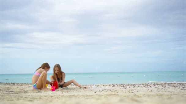 Zwei Kinder basteln Sandburg und spielen am tropischen Strand — Stockvideo