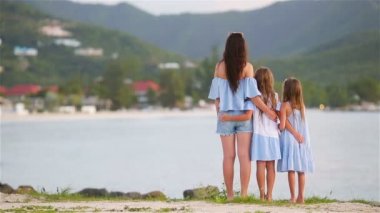Güzel anne ve sevimli küçük kızları sahilde