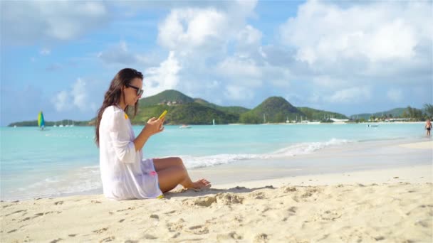 Jonge vrouw met telefoon op tropisch strand. — Stockvideo