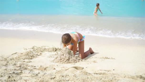 Чарівні маленькі дівчата під час літніх канікул на пляжі — стокове відео