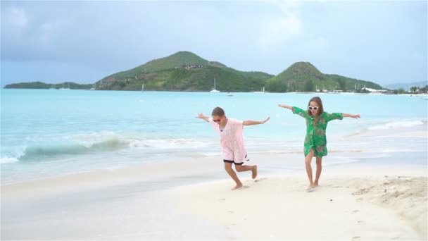 Маленькие веселые веселые девочки веселятся на тропическом пляже, играя вместе. Медленное движение — стоковое видео