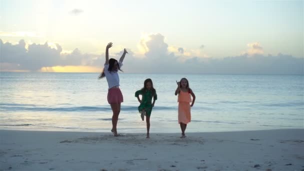 Adorables niñas y madre joven divirtiéndose en la playa blanca . — Vídeo de stock