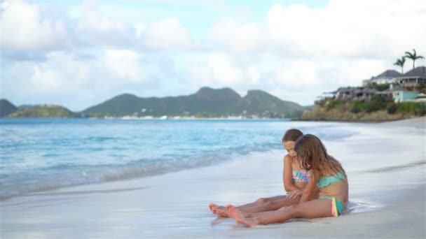 Adorables niñas jugando con arena en la playa . — Vídeos de Stock