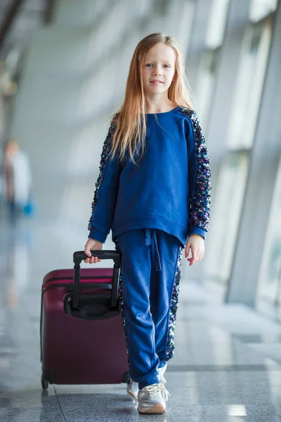 Adorable little girl in airport with her luggage — Stock Photo, Image