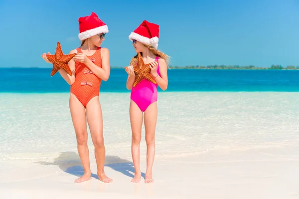 Bedårande små flickor med sjöstjärnor på stranden — Stockfoto